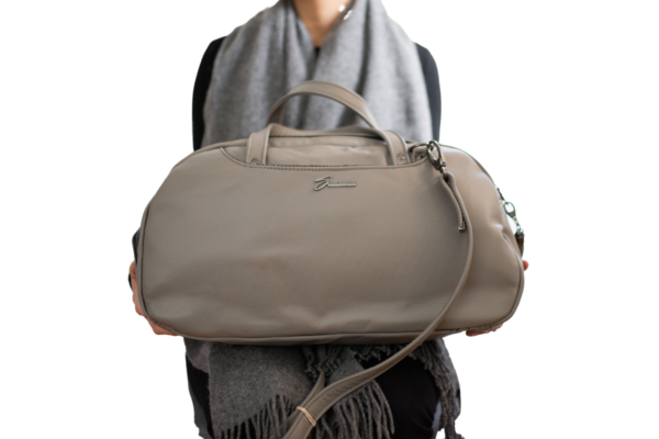 woman holding the grey Travel Bag from Swagger leather.