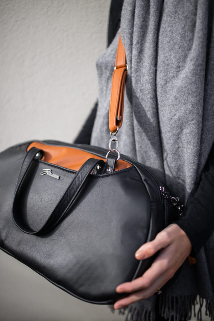 Woman holding the Travel Bag from Swagger leather.